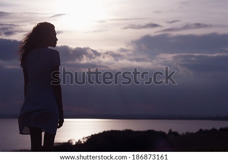 Free woman enjoying freedom feeling happy at beach at sunset. Beautiful serene relaxing woman in pure happiness and elated enjoyment with arms raised outstretched up.