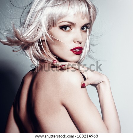 Portrait of a beautiful blonde girl in studio with hair flying