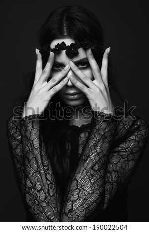 Studio portrait of a beautiful girl, hands on face, black and white photography