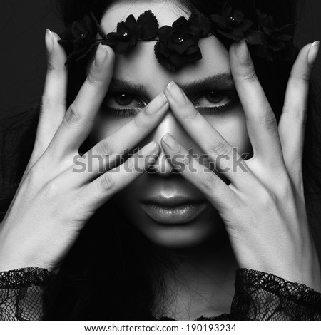 Studio portrait of a beautiful girl, hands on face, black and white photography, close up