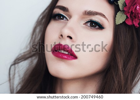Portrait of  young brunette girl with flowers in hair and makeup, beauty concept