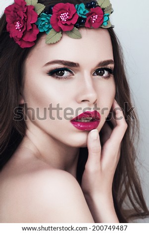 Portrait of beautiful brunette girl with flowers in hair and makeup, beauty concept