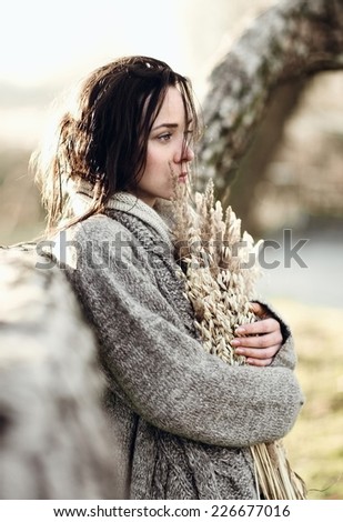 Portrait of a beautiful sad brunette girl outdoors in autumn