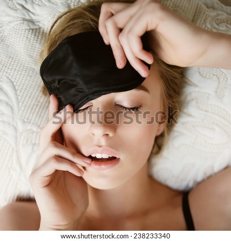 Portrait of a beautiful young blonde woman sleeping in a sleeping mask