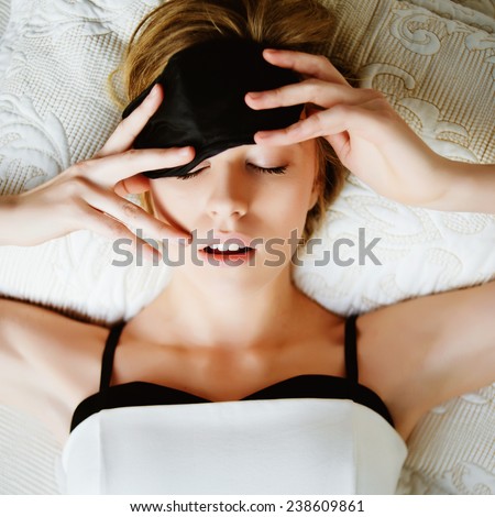 Portrait of a beautiful young blonde woman sleeping in a mask for sleep