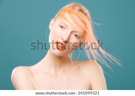 Portrait of beautiful girl with orange hair on a blue background