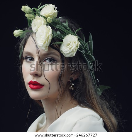 Portrait of a beautiful young girl with a wreath of flowers on her head