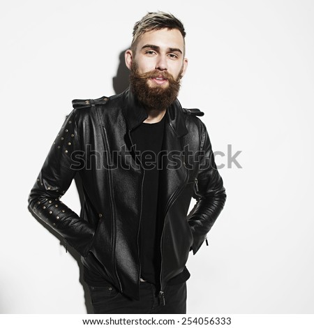 Portrait of a young bearded man in a leather jacket on a white background