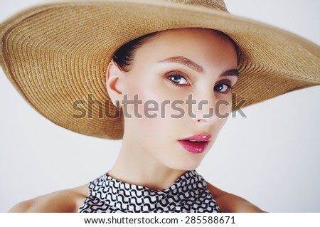 beautiful brunette cute girl in a hat in the studio, the concept of beauty and health