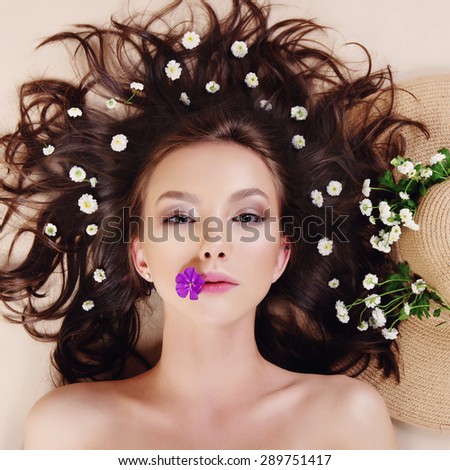 Portrait of a beautiful young girl with flowers in her hair, spa concept