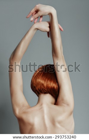 Portrait of the back of a girl with short red hair in a studio