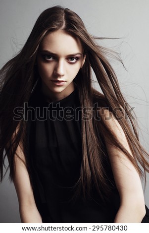 Portrait of a beautiful brunette girl with long hair in the studio, the concept of beauty and health