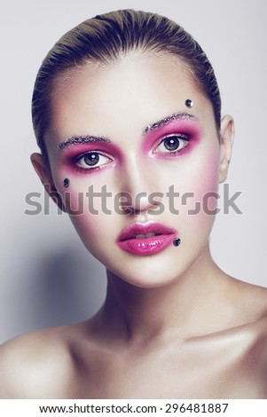 Portrait of a beautiful young girl in the studio on a white background with creative makeup