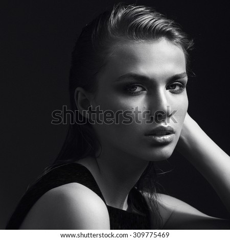 Black and white portrait of a beautiful girl in the studio on a black background, the concept of beauty