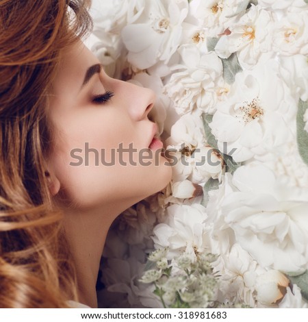 Portrait of a beautiful girl on a background of white flowers