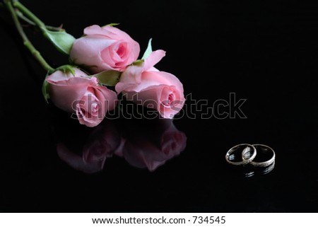  roses and wedding rings reflected in black surface wedding invitation