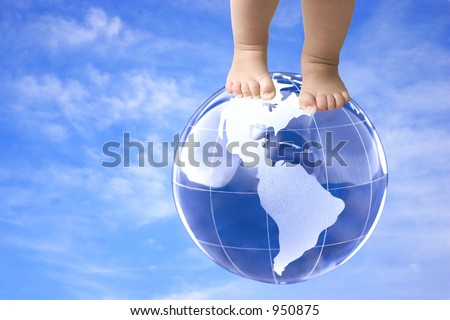 On top of the world (baby feet on globe against blue sky)