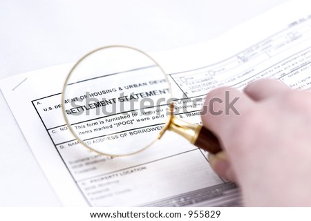 Settlement statement magnified with glass before signing