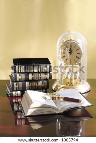 open book on the table and clock to remind how fast the time goes by, when you are reading a good book...