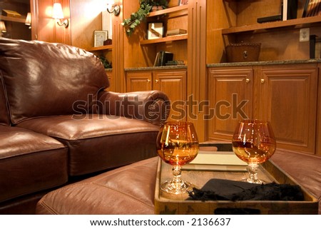 brandy glasses on leather ottoman in a living room