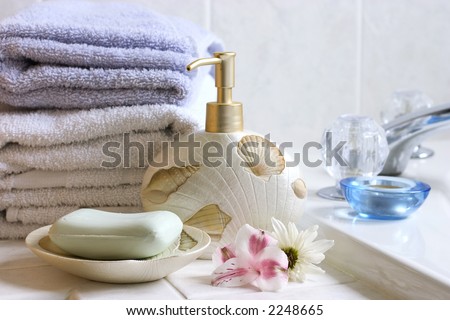 Bath still life ( soap bar, soap pump, flowers, towels)