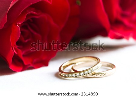 stock photo wedding rings and red roses on background