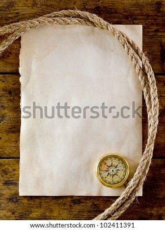 old compass and rope on vintage paper