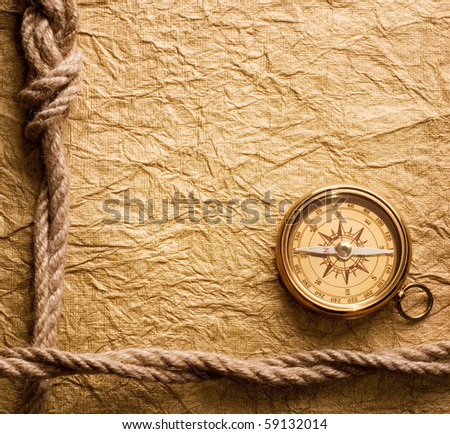 old compass and rope on vintage paper