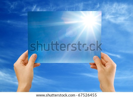 The sun image in hands against the sky