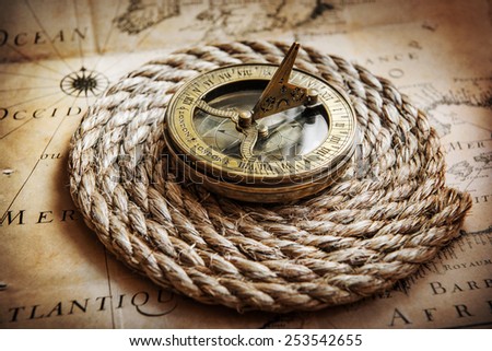 Old compass on vintage map. Adventure stories background