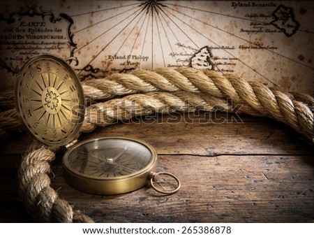 old compass and rope on vintage map