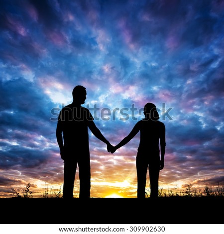 Silhouette of young couple. The concept on the theme of love. Elements of this image furnished by NASA.