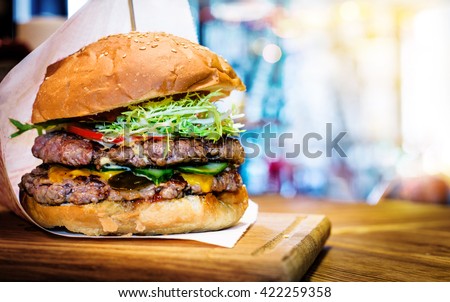 Fresh burger closeup on wooden table.