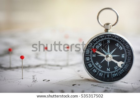 Magnetic compass on a world map conceptual of global travel , tourism and exploration. Macro photo.