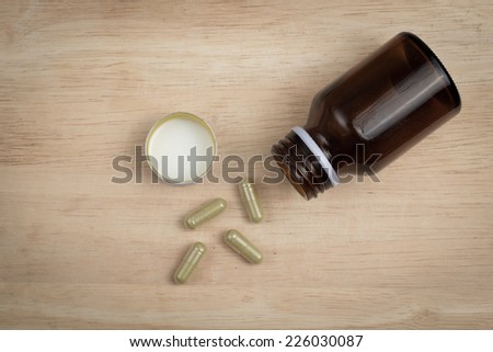 some capsule and the empty bottle on the wood block