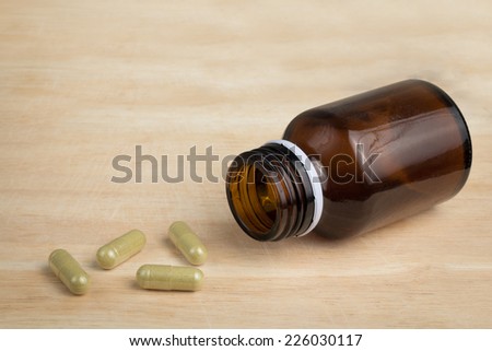 some capsule and the empty bottle on the wood block