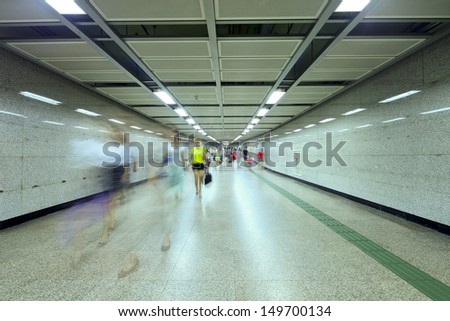 business people walking in metro station tunnel for transfer