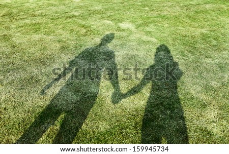 shadow of lover hand in hand in sunset