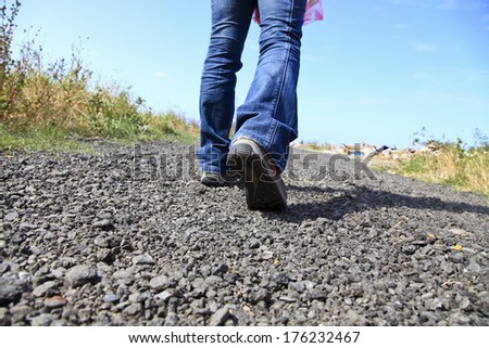 walking with blue jeans and hiking boot in countryside