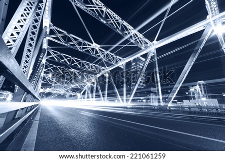 cars run fast through the colorful steel bridge with long tail at night
