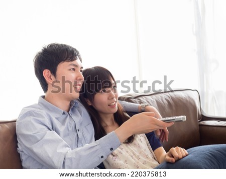 Young couple watching TV in the sofa of the living room