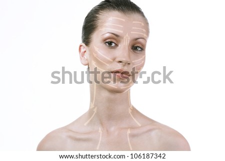 Beautiful girl shows a schematic drawing of cream on the face and neck. Portrait of beautiful woman with brown eyes.