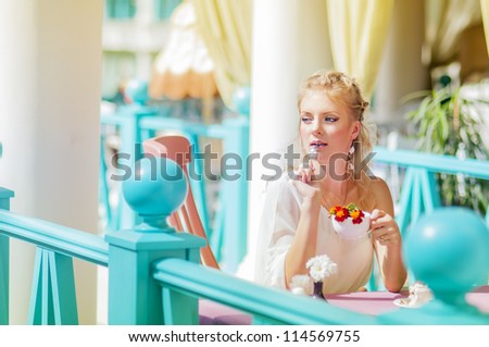 Young woman dreams. Next to her is cake.  Woman holding a cup of tea with flower petals.