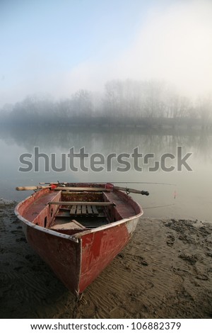 Old boat on the river bank. The river in the mist.
