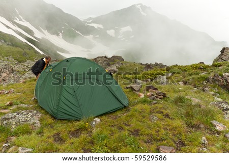 Backpacker wants to get in the tent, before rain.