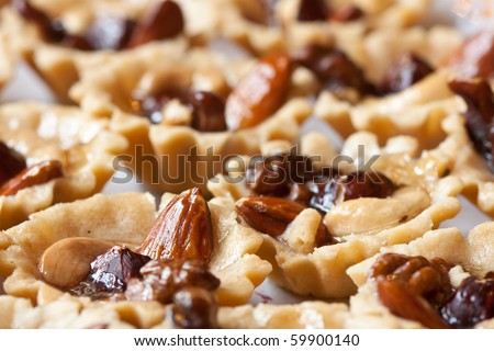 Close-up background of pastry cakes, with chestnut, walnut, hazelnut, and almond nuts. Focused on almond.