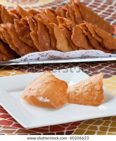Pastry cakes with nuts on white plate in cafe, with cake background.