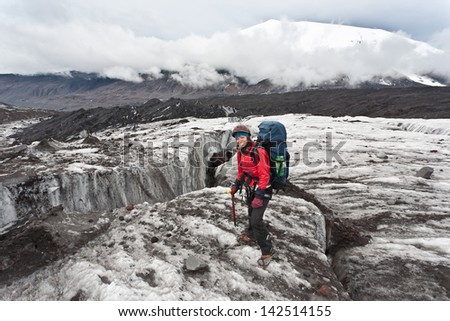 Hiker moving on volcano land in Kamchatka, Russia.