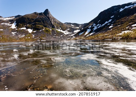 Frozen pond with snow on Senja island, Norway.