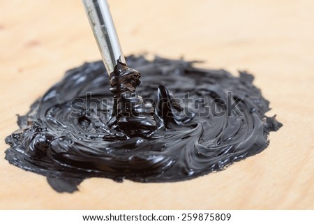 Macro view of oil pant on wooden background.